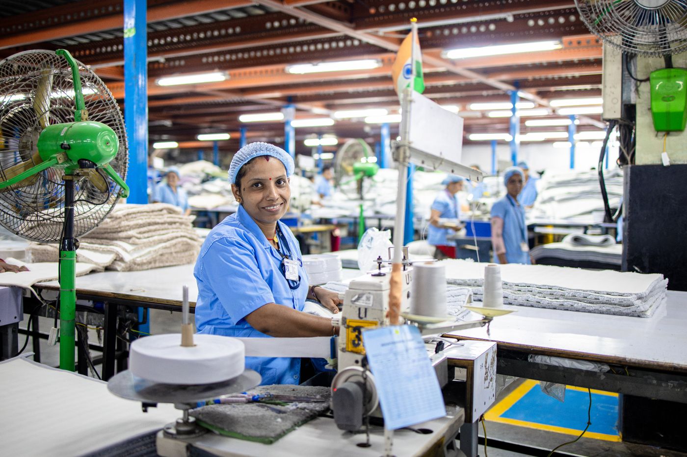 Ouvrière conduisant une machine à coudre dans une usine textile